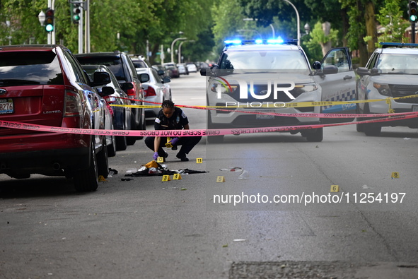 A crime scene investigator is placing evidence markers at the crime scene to show where a recovered firearm, articles of clothing, and other...