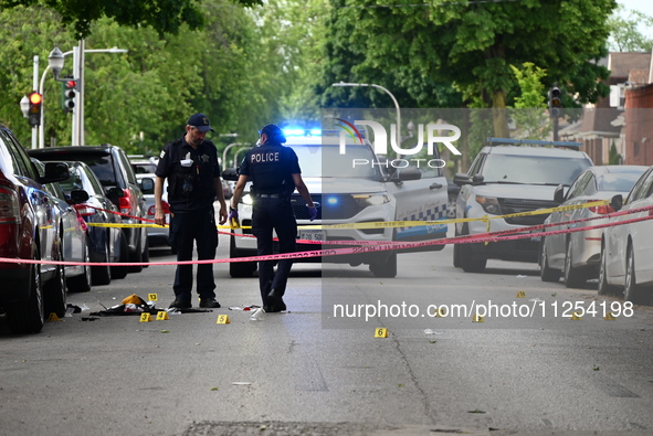 Crime scene investigators are placing evidence markers at the crime scene to show where a recovered firearm, articles of clothing, and other...