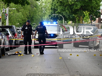 Crime scene investigators are placing evidence markers at the crime scene to show where a recovered firearm, articles of clothing, and other...