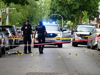 Crime scene investigators are placing evidence markers at the crime scene to show where a recovered firearm, articles of clothing, and other...