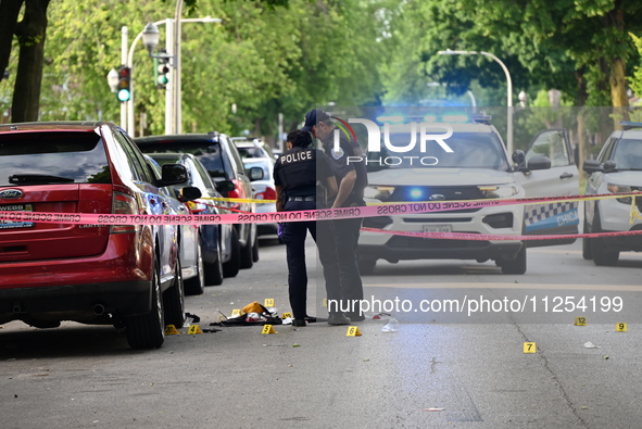 Crime scene investigators are placing evidence markers at the crime scene to show where a recovered firearm, articles of clothing, and other...