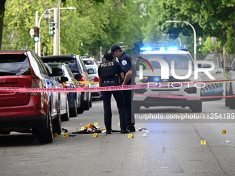 Crime scene investigators are placing evidence markers at the crime scene to show where a recovered firearm, articles of clothing, and other...