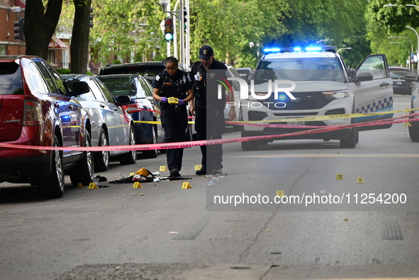 Crime scene investigators are placing evidence markers at the crime scene to show where a recovered firearm, articles of clothing, and other...