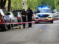 Crime scene investigators are placing evidence markers at the crime scene to show where a recovered firearm, articles of clothing, and other...