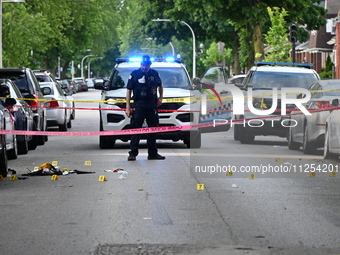 Crime scene investigators are placing evidence markers at the crime scene to show where a recovered firearm, articles of clothing, and other...