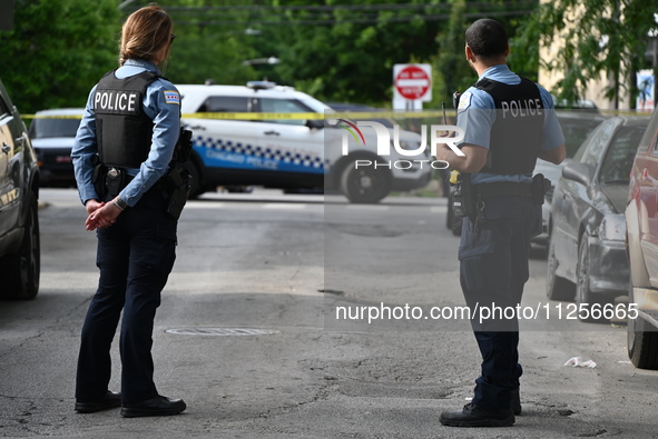 Police officers are guarding the crime scene. A 15-year-old male is being critically wounded in a shooting in Chicago, Illinois, United Stat...