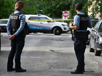 Police officers are guarding the crime scene. A 15-year-old male is being critically wounded in a shooting in Chicago, Illinois, United Stat...