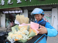 A courier is delivering flowers at a florist in Funing county, Yancheng city, East China's Jiangsu province, on May 20, 2024. (