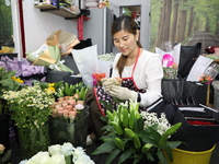 An employee is packing bouquets according to an order at a flower shop in Funing county, Yancheng city, East China's Jiangsu province, in Ya...