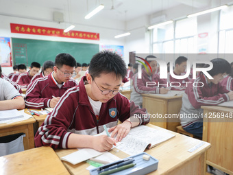 Grade three high school students who are about to take the National college entrance examination are reviewing in a self-study class at Gany...