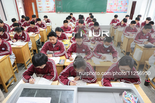 Grade three high school students who are about to take the National college entrance examination are reviewing in a self-study class at Gany...