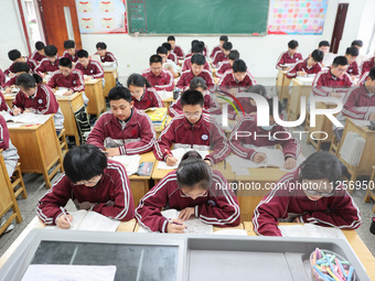 Grade three high school students who are about to take the National college entrance examination are reviewing in a self-study class at Gany...