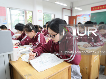 Grade three high school students who are about to take the National college entrance examination are reviewing in a self-study class at Gany...