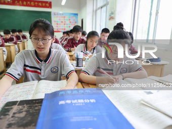 Grade three high school students who are about to take the National college entrance examination are reviewing in a self-study class at Gany...