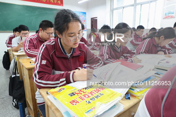 Grade three high school students who are about to take the National college entrance examination are reviewing in a self-study class at Gany...