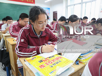 Grade three high school students who are about to take the National college entrance examination are reviewing in a self-study class at Gany...