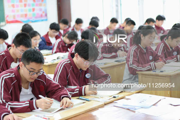 Grade three high school students who are about to take the National college entrance examination are reviewing in a self-study class at Gany...