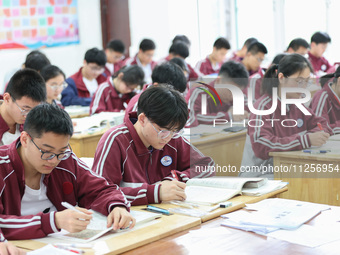 Grade three high school students who are about to take the National college entrance examination are reviewing in a self-study class at Gany...