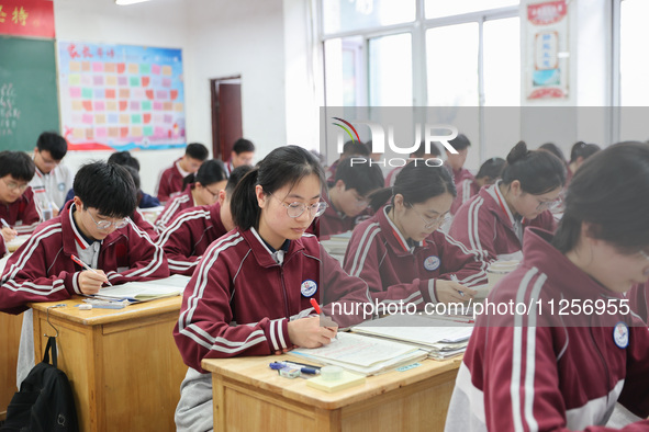 Grade three high school students who are about to take the National college entrance examination are reviewing in a self-study class at Gany...