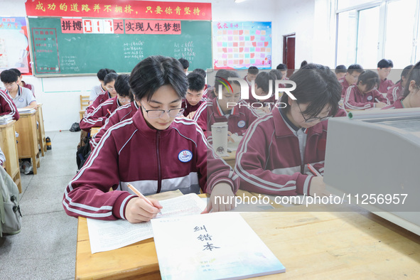 Grade three high school students who are about to take the National college entrance examination are reviewing in a self-study class at Gany...