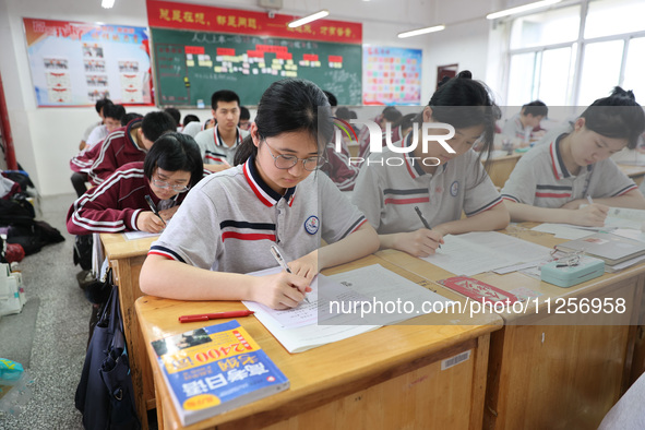 Grade three high school students who are about to take the National college entrance examination are reviewing in a self-study class at Gany...