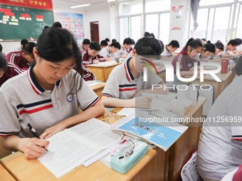 Grade three high school students who are about to take the National college entrance examination are reviewing in a self-study class at Gany...