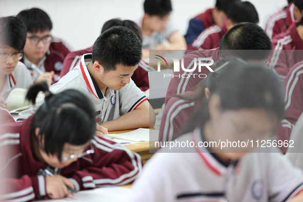 Grade three high school students who are about to take the National college entrance examination are reviewing in a self-study class at Gany...