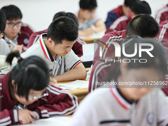 Grade three high school students who are about to take the National college entrance examination are reviewing in a self-study class at Gany...