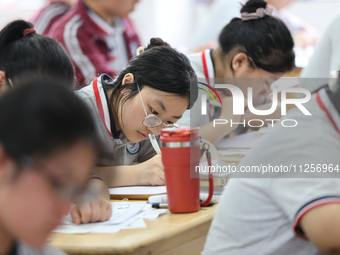 Grade three high school students who are about to take the National college entrance examination are reviewing in a self-study class at Gany...