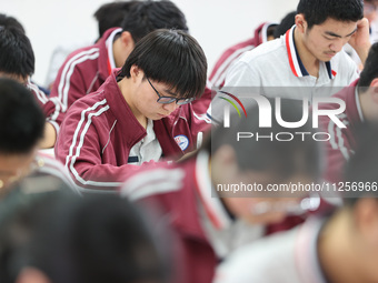 Grade three high school students who are about to take the National college entrance examination are reviewing in a self-study class at Gany...