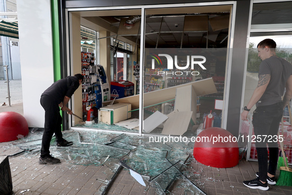 A worker is clearing away glass shards at a petrol station damaged by Russian shelling in Kharkiv, Ukraine, on May 19, 2024. NO USE RUSSIA....