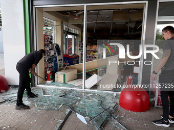 A worker is clearing away glass shards at a petrol station damaged by Russian shelling in Kharkiv, Ukraine, on May 19, 2024. NO USE RUSSIA....