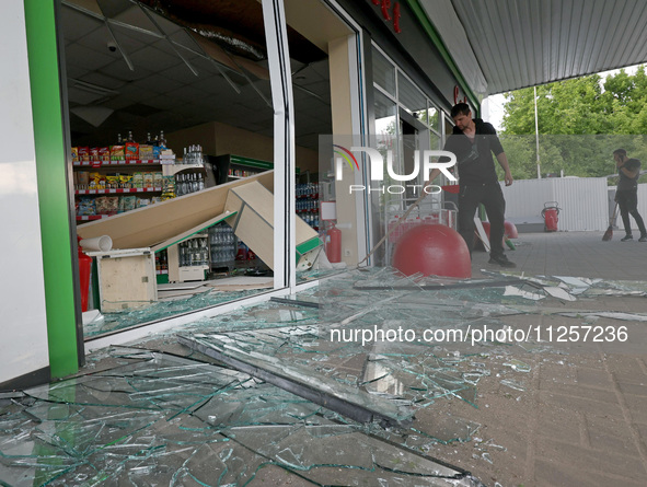 A worker is clearing away glass shards at a petrol station damaged by Russian shelling in Kharkiv, Ukraine, on May 19, 2024. NO USE RUSSIA....