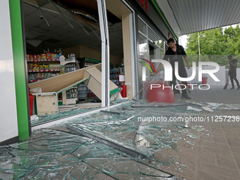 A worker is clearing away glass shards at a petrol station damaged by Russian shelling in Kharkiv, Ukraine, on May 19, 2024. NO USE RUSSIA....