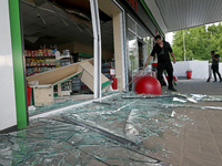 A worker is clearing away glass shards at a petrol station damaged by Russian shelling in Kharkiv, Ukraine, on May 19, 2024. NO USE RUSSIA....