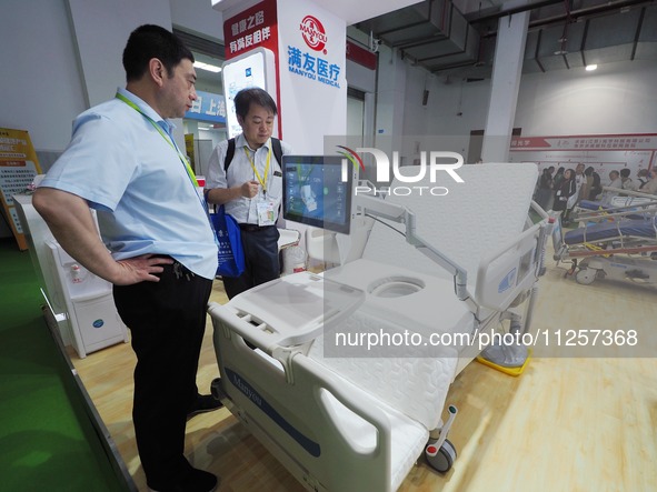 Visitors are visiting an ''electric nursing bed'' at the 32nd China International Health Industry Expo in Beijing, China, on May 20, 2024. 