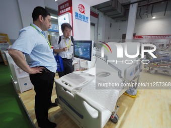 Visitors are visiting an ''electric nursing bed'' at the 32nd China International Health Industry Expo in Beijing, China, on May 20, 2024. (