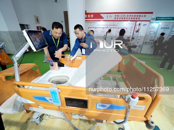 Visitors are visiting a ''Multi-functional intelligent nursing bed'' at the 32nd China International Health Industry Expo in Beijing, China,...