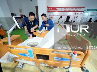 Visitors are visiting a ''Multi-functional intelligent nursing bed'' at the 32nd China International Health Industry Expo in Beijing, China,...