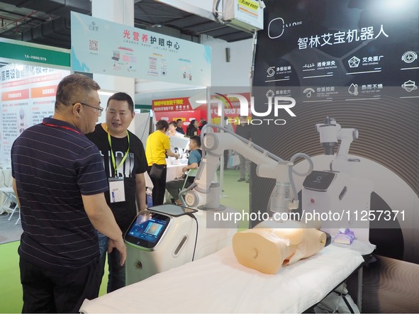 Visitors are visiting a ''physiotherapy robot'' at the 32nd China International Health Industry Expo in Beijing, China, on May 20, 2024. 