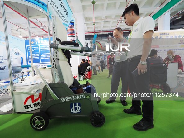 Visitors are visiting a ''lower limb rehabilitation robot'' at the 32nd China International Health Industry Expo in Beijing, China, on May 2...