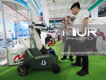 Visitors are visiting a ''lower limb rehabilitation robot'' at the 32nd China International Health Industry Expo in Beijing, China, on May 2...