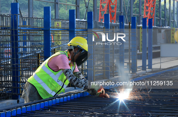 Workers are working at the construction site of a highway in Jiangbian village, Liuzhou city, South China's Guangxi Zhuang Autonomous region...