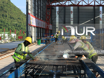 Workers are working at the construction site of a highway in Jiangbian village, Liuzhou city, South China's Guangxi Zhuang Autonomous region...