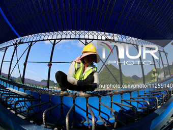 Workers are working at the construction site of a highway in Jiangbian village, Liuzhou city, South China's Guangxi Zhuang Autonomous region...