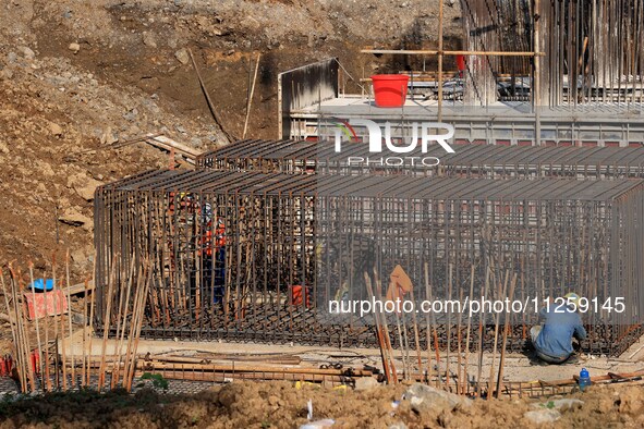 Workers are working at the construction site of a highway in Jiangbian village, Liuzhou city, South China's Guangxi Zhuang Autonomous region...