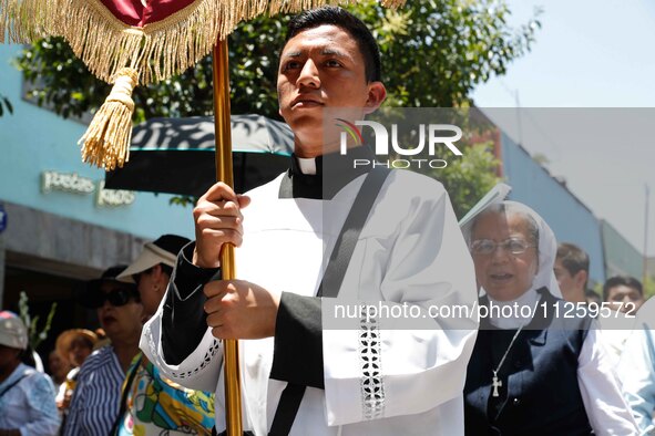 A priest is taking part in the traditional downing of the Virgen de Ocotlan. In this procession, the virgin is visiting different emblematic...