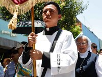 A priest is taking part in the traditional downing of the Virgen de Ocotlan. In this procession, the virgin is visiting different emblematic...