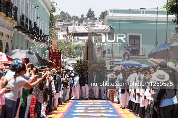 People are carrying the Virgen de Ocotlan while walking on a sawdust carpet during the traditional downing of the Virgen de Ocotlan. In this...