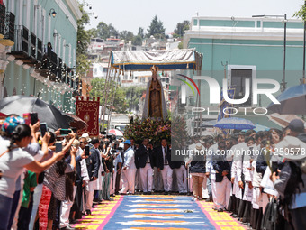 People are carrying the Virgen de Ocotlan while walking on a sawdust carpet during the traditional downing of the Virgen de Ocotlan. In this...